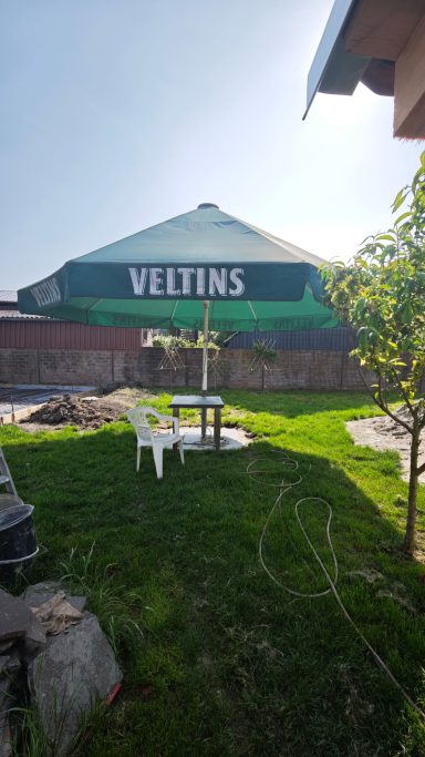 Pavillon mit dem Schriftzug "VELTINS" in einem grünen Garten.